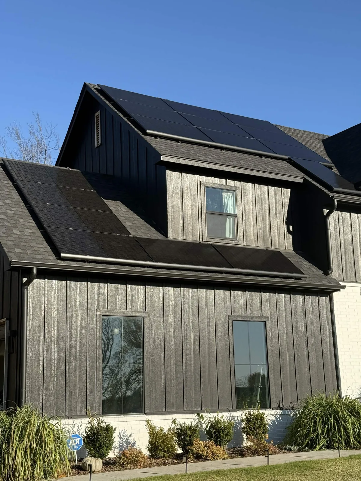 Modern black Central Illinois home with solar panels fitted across three separate roof planes