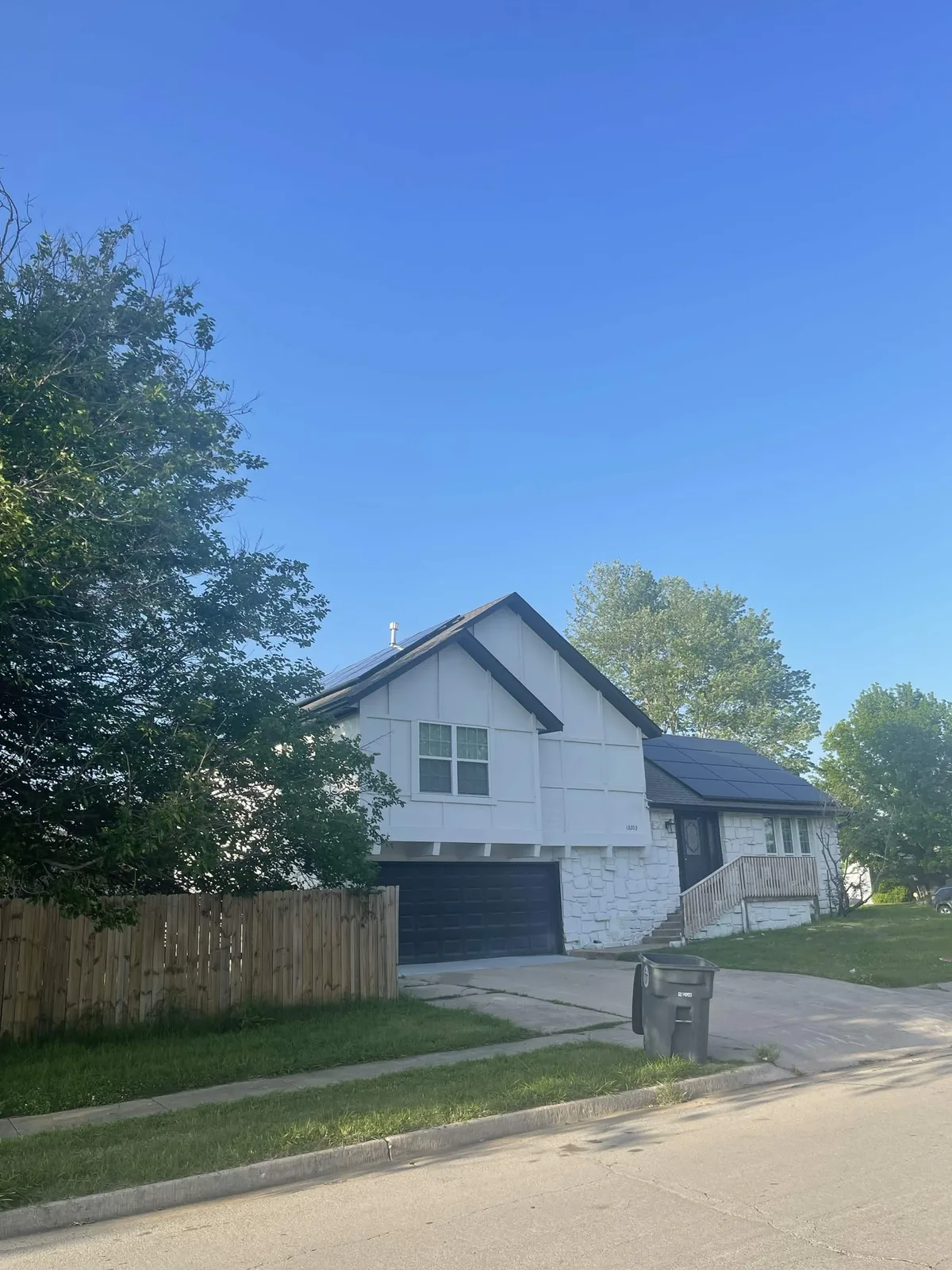 White two-story Southern Illinois home with rooftop solar panels seen from the street